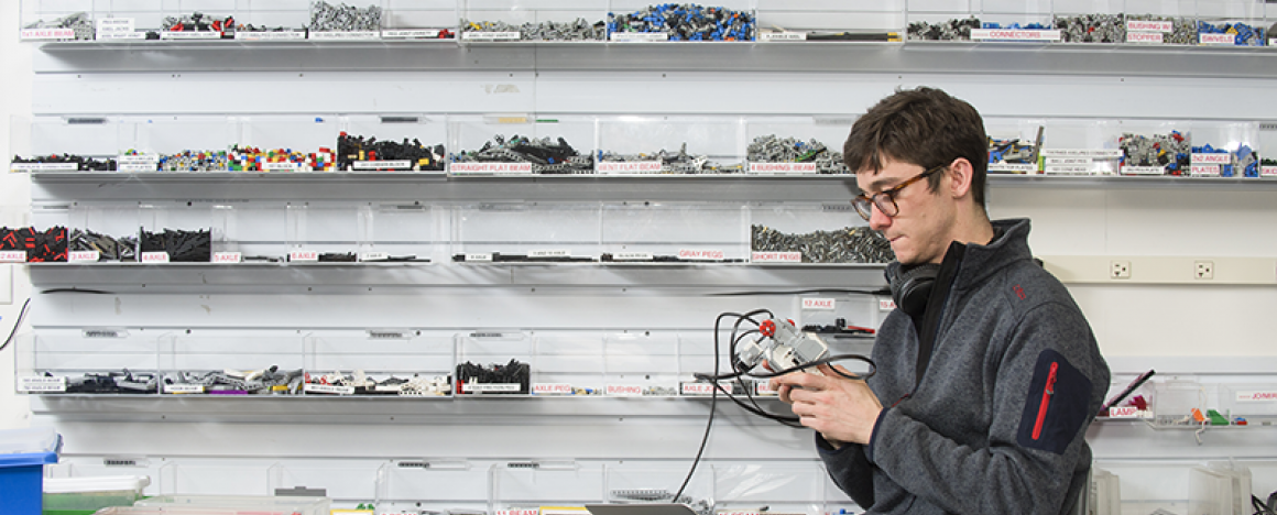 Student holding robotic device with wires