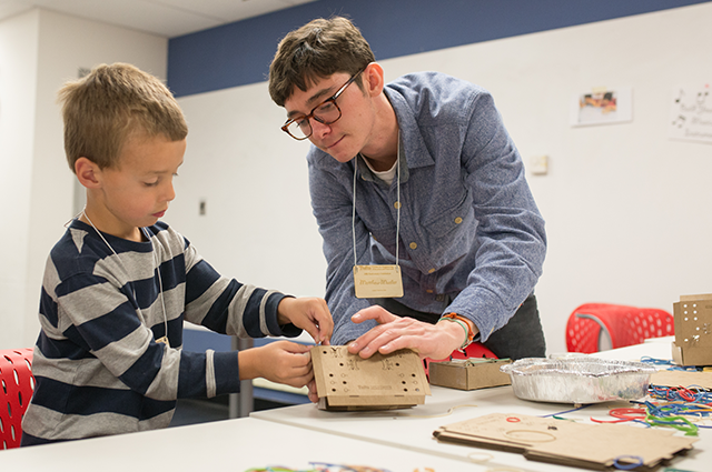 A student helps an elementary schooler on a design project with Tufts CEEO.