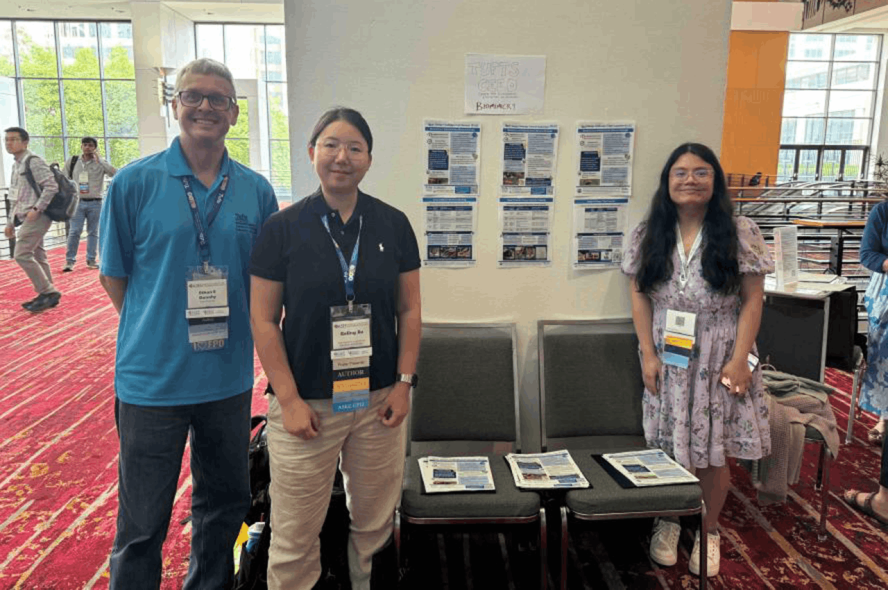 A faculty member and two students present a poster at the ASEE conference.