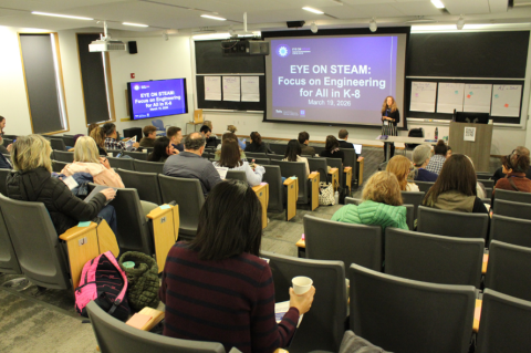 Attendees gather in Robinson Hall for the Eye on STEAM conference. The screen up front reads Eye on STEAM: Focus on Engineering for All K-8.